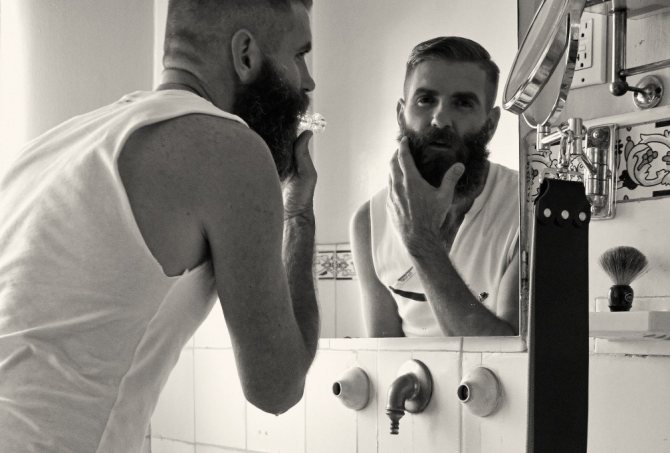 бородач смотрит в зеркало